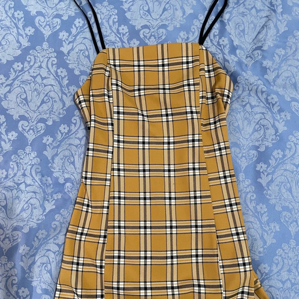 Yellow plaid mini dress with black straps.